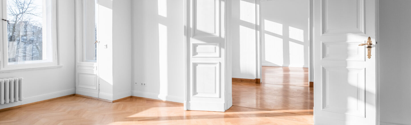 Blick in eine leere Wohnung mit weißen Wänden und Türen