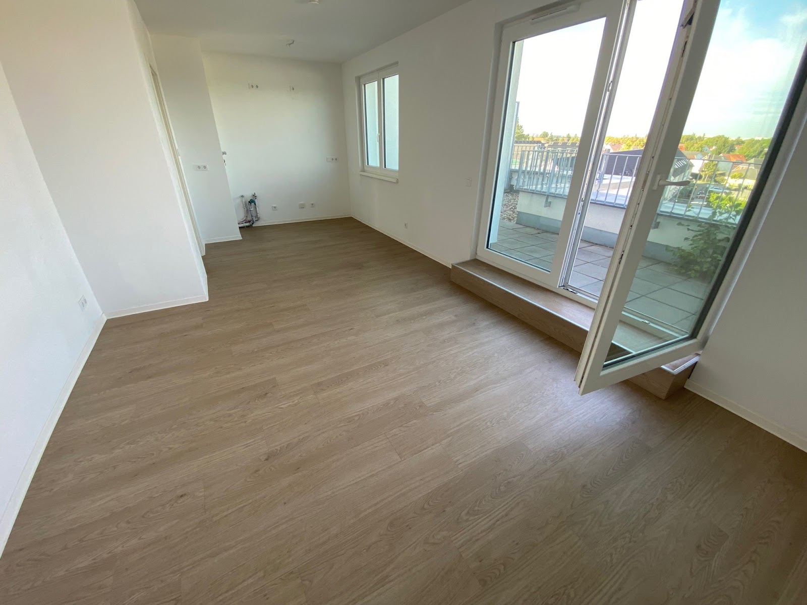 Wohnzimmer mit Zugang zur Terrasse u. offenem Küchenbereich